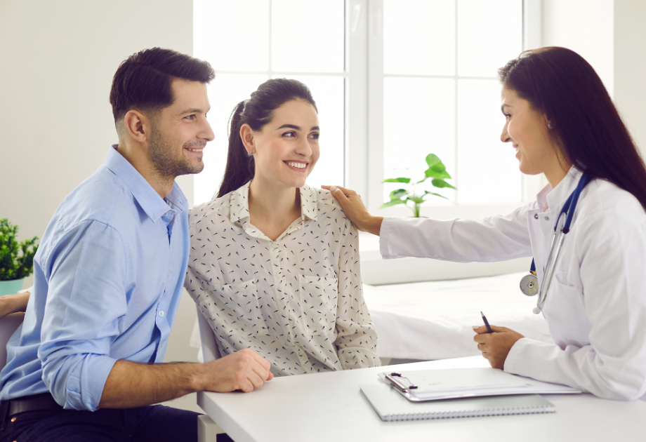 a doctor comforting a man in a woman in a conversation